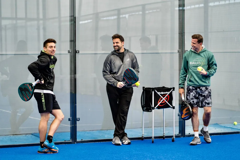Entrenador de pádel con sus alumnos en pista